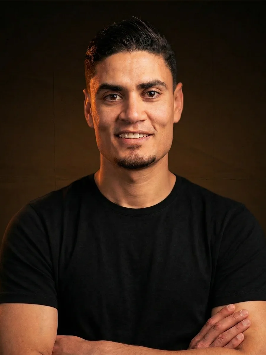 Mostafa Zoheer, portrait in a black t-shirt on a warm dark background.