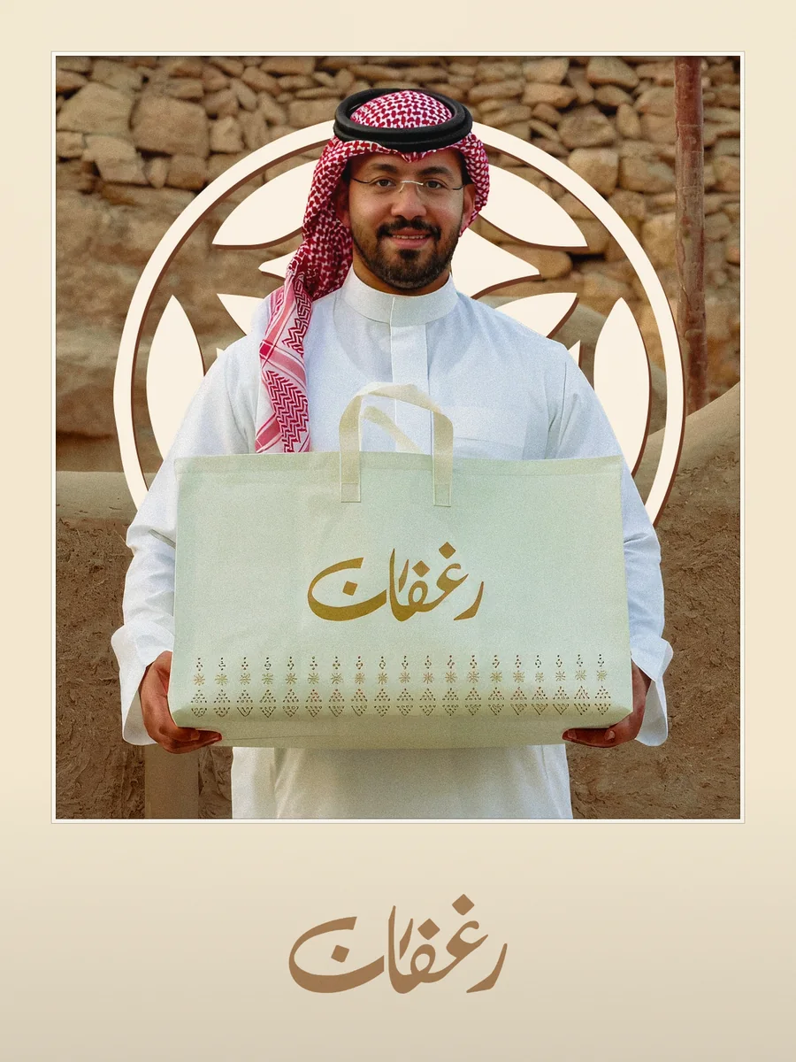 Rughfan: a man in a red shemagh holding the Rughfan bag in front of a mud wall and the brand emblem.